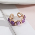 Vue détaillée d'une bague ajustable dorée ornée de cinq pierres violettes serties clos - Améthyste Pierre Naturelle