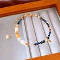 Detalle de pulsera de cuentas de piedra de colores con colgante de corazón en madera - Colorido