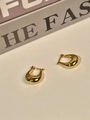 Detail of elegant gold tulip U-shaped earrings on a minimalist cream background - Gold