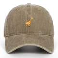 Detail der Giraffen-Stickerei und gewaschener Khaki-Stoffstruktur auf der Baumwollkappe - Khaki