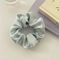 Detail of light blue satin scrunchie showing smooth silk texture and elegant folds - No Card / Apple Green