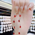 Elegant gold-tone tassel earrings featuring red teardrop gems and sparkling rhinestones - Red