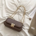 Borsa a spalla retrò in pelle marrone scuro con catena dorata su sfondo di tessuto bianco - caffè