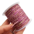 Detailed macro of pink, yellow and white braided cotton cord on a white plastic spool - Approx. 2.0mm / Pink, Yellow and White