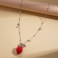 Macro-opname van de rode aardbeien hanger met parels aan een fijne zilverkleurige ketting - Dunne Kralenketting met Parel en Ster