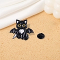 Detail of gothic black cat enamel pin with bat wings and a small white blade accessory - Cat with Bat Wings and Knife (CZ0318-3)