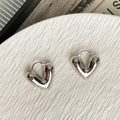 Dettaglio di orecchini a cerchio a cuore cavo in argento lucido su vassoio bianco - Circa 2,8 cm / Argento