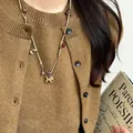 Retro-Halskette mit Holzpferd, Sternanhänger, khakifarbener Kordel und roten Perlen - Holz Schaukelpferd Perlen Beige Seil Stil