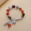Ethnic red agate bracelet with silver elephant and fish charms on beige background - Style D: Coconut Shell Red Agate Elephant Bracelet