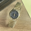 Detail of gold elastic steel band and black quartz watch face with luminous numbers - Women's Watch / Gold Band Black Dial