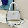 White pebbled leather tote bag with gold P hardware and wide letter-printed strap - White