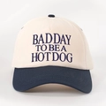 Detail shot of navy blue embroidery text on a cream cotton baseball cap - Cream/Navy Blue