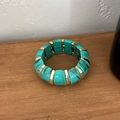 Macro detail of turquoise marble resin bracelet with gold metal spacers on wood - Turquoise