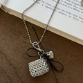 Détail du collier à perles argentées avec pochette tressée et nœud en ruban noir - Nœud Noir / Argenté