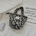 Détail du sac à main en peluche léopard montrant la texture douce et l'étiquette tissée - Léopard en Velours d'Agneau Gris