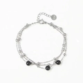 Dettaglio di un bracciale multistrato in acciaio inossidabile con perline argentate - Argento + Onice Nero