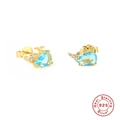 Macro detail of whale-shaped silver stud earrings with blue gems and golden finish - Whale-Sea Blue Zirconia