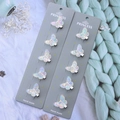 Detalle de diez pinzas de mariposa con acabado iridiscente sobre tejido suave - Pinzas de Mariposa Pequeñas - Juego de 10