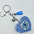 Blue rhinestone heart evil eye keychain with tassel and bell accessory on light background - Sky Blue