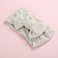 Detailed macro view showing the soft cable knit texture of this baby bow headband. - Off-White