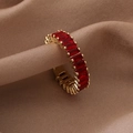 Macro di anello dorato con cristalli rossi rettangolari su seta color beige - Aperto Regolabile / Oro Rosso Zircone