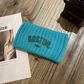 Nahaufnahme eines blaugrünen Strickstirnbands mit Boston-Stickerei auf Holz - Cyan