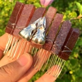 Macro shot of dark red crystal hair comb with silver crow skull accents and metal wire - Strawberry Quartz + Silver Crow Skull