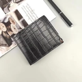 Portefeuille pour homme en cuir embossé crocodile noir avec coin métallique sur un bureau - Noir
