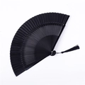 Detailed view of a black Chinese folding fan with intricate hollow patterns and silk tassel - Small Window Hollow Black Satin Face