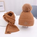 Detail von karamellbraunem Strickset mit Bärenstickerei und Bommel für Kinder im Winter - Kaffeebraun