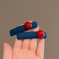Set of two blue fabric hair clips with red bead accents for women's winter styling - Blue and Red Contrast