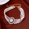 Dettaglio macro della collana di perle a più strati con pendente in cristallo su seta marrone - Collana di perle a più strati - Oro - Bianco - Ciondolo blu