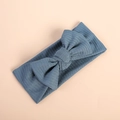 Close-up of blue-grey ribbed knit bow headband for babies on a beige background - Dark Blue