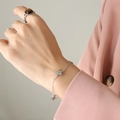 Bracelet à breloques étoiles en argent avec zircons porté sur fond de costume rose - 15+5cm / Bracelet Argent