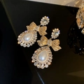 Detalle de pendientes de lazo dorados con perlas de gota y circonitas brillantes - Dorado (Pin de Plata S925)