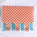 Orange and beige checkered hair claw clip with blue glitter teeth on white background - Blue + Orange Plaid