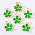 Detail of six green enamel four-leaf clover charms with gold frames and rhinestones - Green