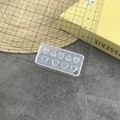 Macro view of transparent silicone mold featuring eight heart patterns on a cutting mat - #170 Hollow Heart