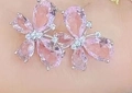 Orecchini a fiore con gemme rosa e cristalli mostrati indossati all'orecchio - Placcato Oro Bianco Pietra Rosa