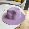 Detailed close-up of lavender woven straw sun hat with textured flat top design - Purple