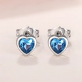 Macro shot of silver heart earrings with sparkling blue sapphire cut stones - Blue