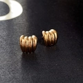 Close-up of golden ball earrings with vintage wrinkled texture on a dark grey fabric background - Metal Ribbed Stripe Style / Gold