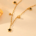 Collar de cadena dorada con colgantes de estrellas negras y cuentas sobre fondo rugoso - Collar de Estrella de Concha Negra Dorada