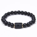 Macro view of matte black agate beads and Sagittarius zodiac metal charm bracelet - Sagittarius