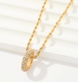 Detalle macro del collar de cadena dorada con colgante circular de circonitas brillantes - Estilo de Colgante Redondo con Pavé Completo