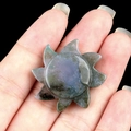 Handheld sun-shaped moss agate crystal carving with natural green and purple textures - India Agate