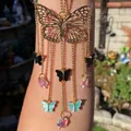Detail of butterfly suncatcher with gold tassels and crystal prism on arm display - Gold Butterfly Rainbow Crystal