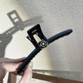 Detail der eleganten schwarzen Kamelien-Haarklammer mit Goldrand in der Hand - Schwarze Kamelien Haarkralle