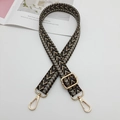 Detail of adjustable woven bag strap featuring a black and brown arrow pattern with gold clips - Black Grey Camel + Gold Hook
