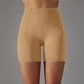 Detail van de naadloze honingraat-gebreide textuur van de bruine yoga-short met hoge taille - Aardgeel
